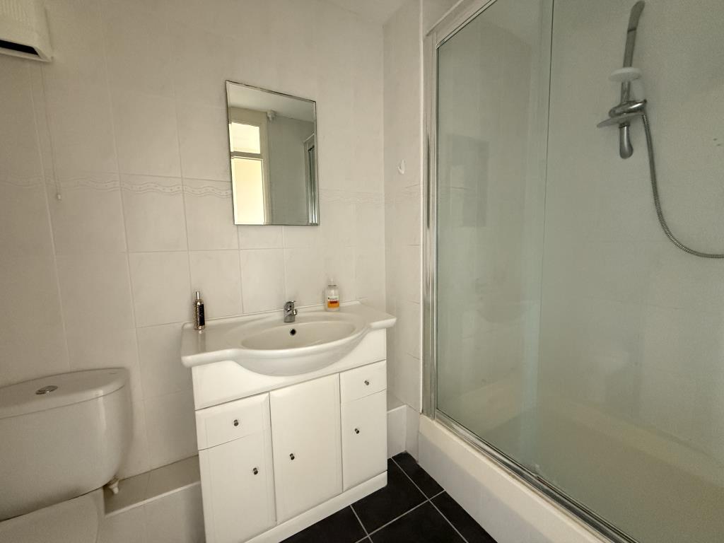 Lot: 126 - TWO-BEDROOM TOP FLOOR FLAT WITH UNINTERRUPTED SEA VIEWS - Bathroom with shower cubicle and white suite